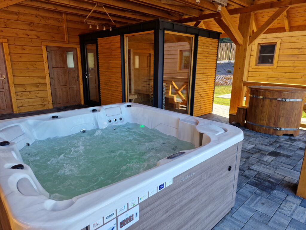 Całoroczna strefa relaksu w obiekcie Serce Beskidu z nowoczesnym jacuzzi, przeszkloną sauną i balią, oferująca relaks i regenerację podczas wyjazdu integracyjnego dla firmy.