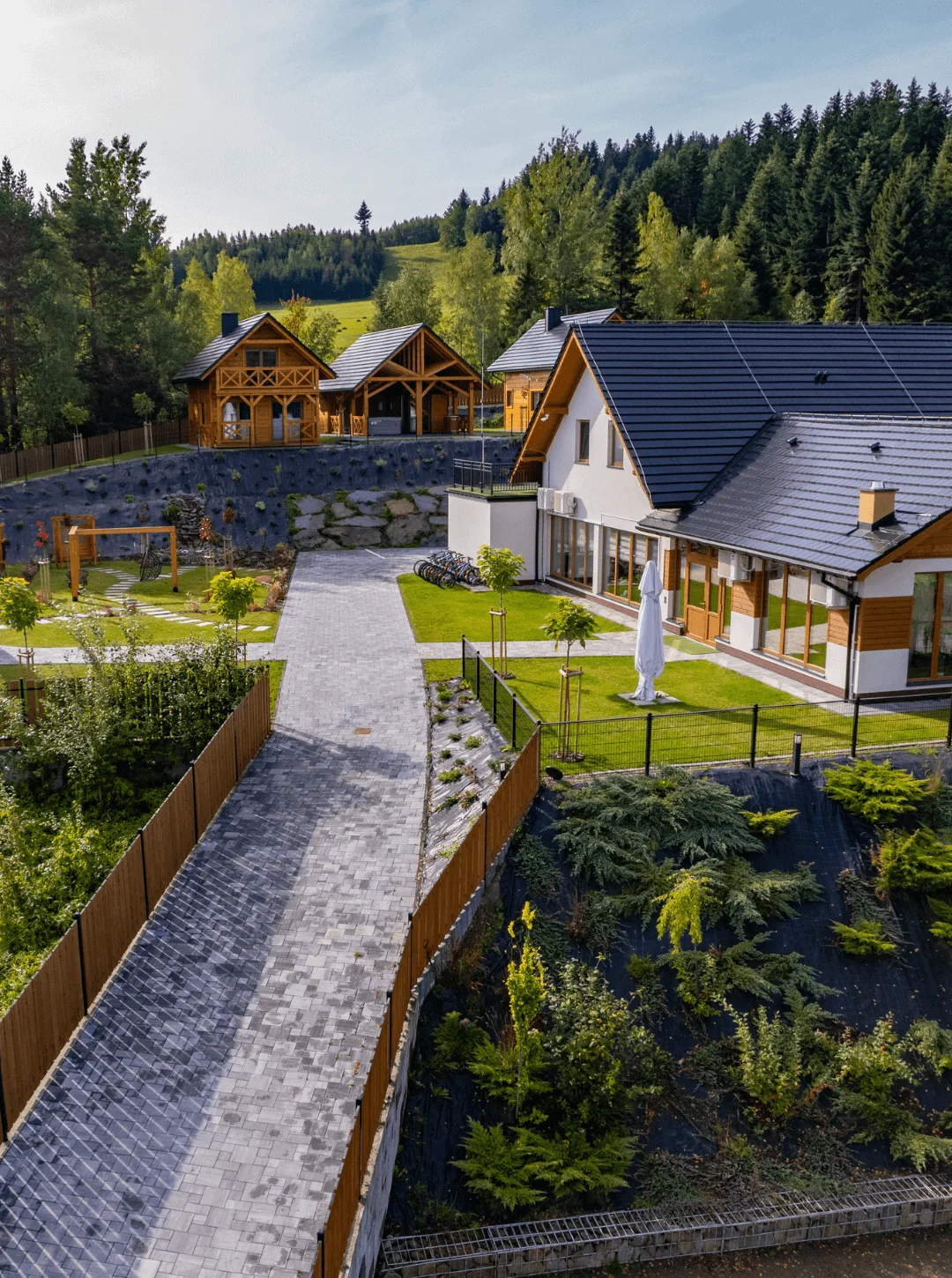 Sala weselna na wesele rustykalne w Beskidach Widok na dom weselny Serce Beskidu z budynkami, wybrukowaną drogą i drewnianymi domkami góralskimi w stylu rustykalnym