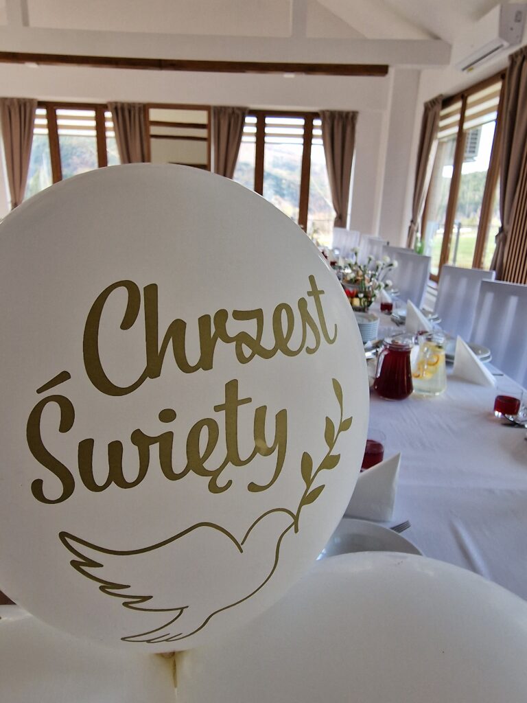 Biały balon z napisem "Chrzest Święty" i nadrukiem gołębicy w obiekcie Serce Beskidu, tworzący wyjątkowy klimat podczas chrzcin w restauracji.