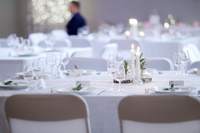 Nastrojowy kadr z elegancko nakrytego stołu w restauracji Serce Beskidu, prezentujący delikatne dekoracje, świece i zastawę, co doskonale obrazuje, jak zorganizować chrzciny w restauracji, aby przyjęcie było wyjątkowe i pełne klasy.